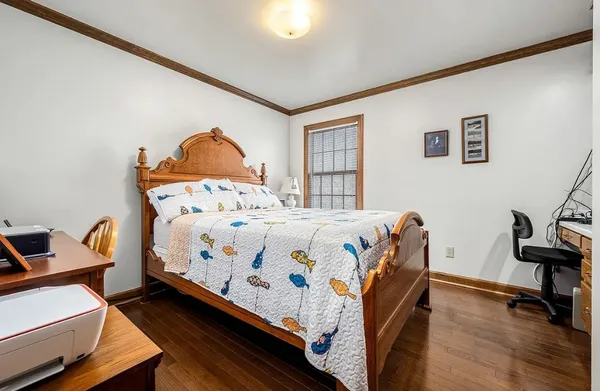 a bedroom with a bed dresser and a window