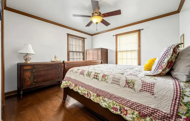 a view of a hallway with wooden floor and a bathroom