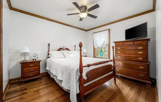 a bedroom with a bed and wooden floor