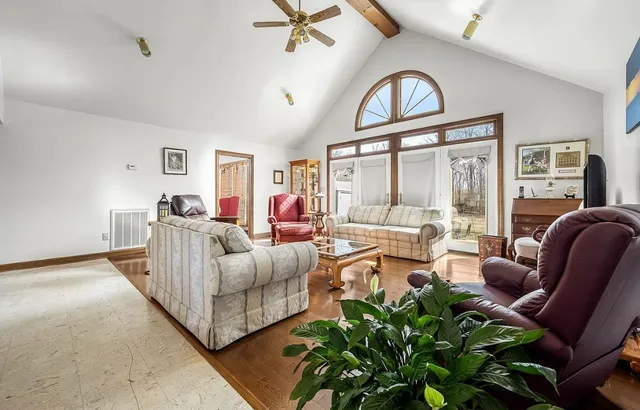 a hallway with a view of living room and wooden floor