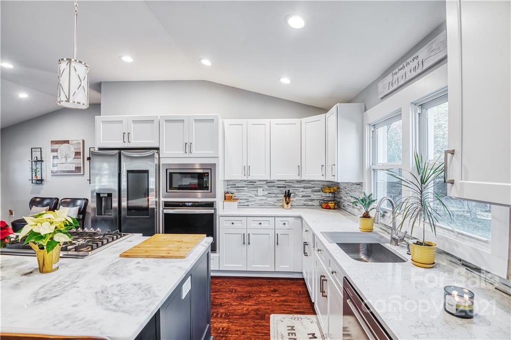 1194 Hensley Road Fort Mill, SC 29715 - Photo 22 of 45 a kitchen with stainless steel appliances granite countertop a sink stove and refrigerator