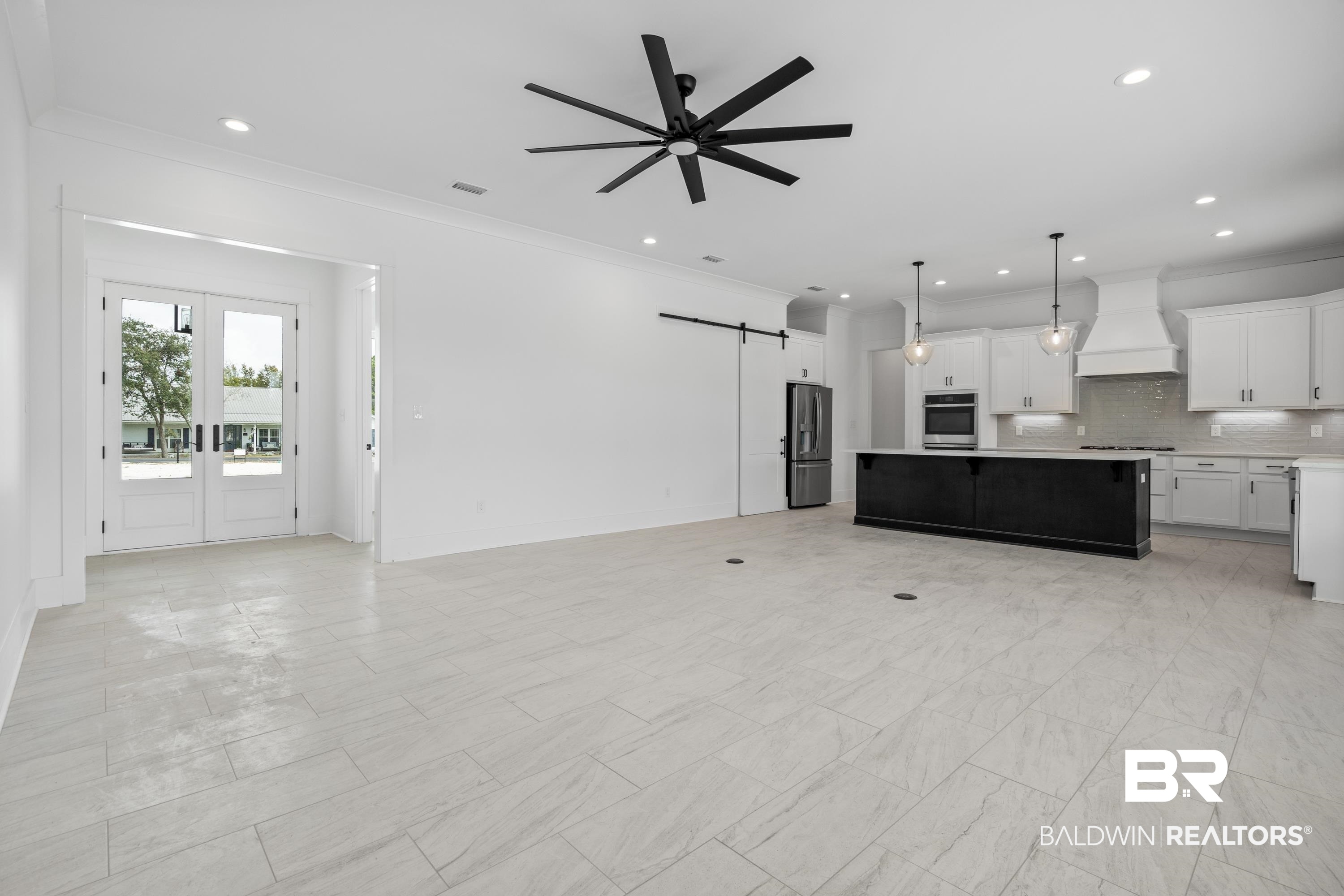 30650 Ono N Loop West Orange Beach, AL 36561 - Photo 3 of 38 Unfurnished living room featuring a barn door, a ceiling fan, recessed lighting, crown molding, and baseboards