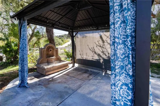 a view of porch with a table and chairs under an umbrella