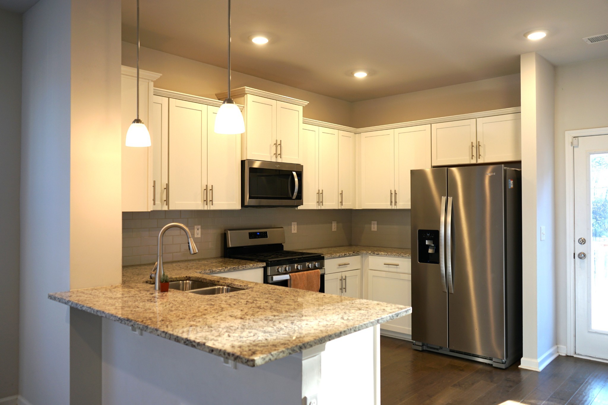 4221 Grapevine Loop Smyrna, TN 37167 - Photo 4 of 18 a kitchen with kitchen island granite countertop a sink refrigerator and microwave