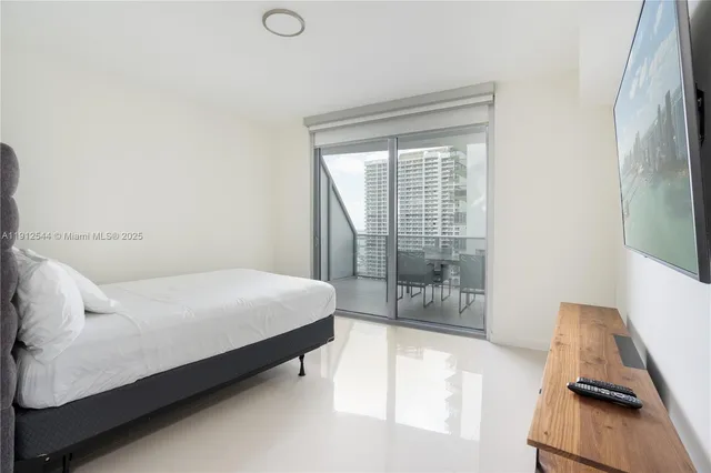 a bed sitting in a bedroom next to a window