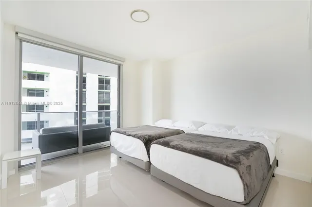 a bedroom with a bed and large window