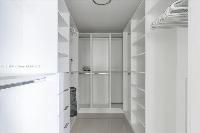 a view of walk in closet with clothes