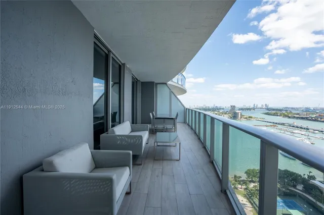 a view of balcony with couches and wooden floor