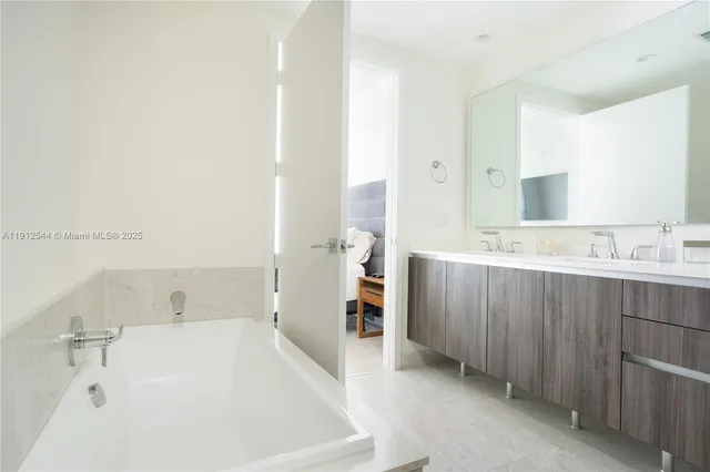 a bathroom with a tub sink and mirror