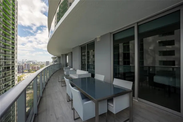 a balcony with table and chairs