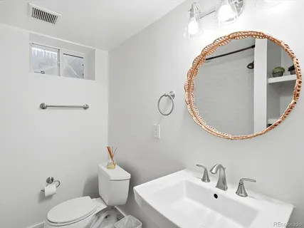 a bathroom with a sink mirror and toilet