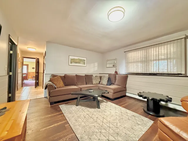 a living room with furniture potted plant and a large window