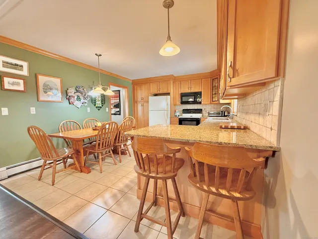 a dining room with furniture and a floor to ceiling window