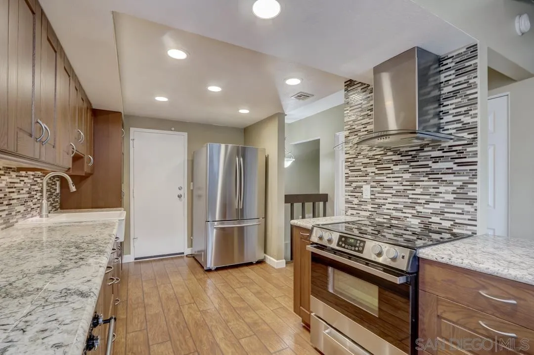 6395 Rancho Mission Road, Unit 15 San Diego, CA 92108 - Photo 12 of 21 a kitchen with stainless steel appliances granite countertop a refrigerator and a stove
