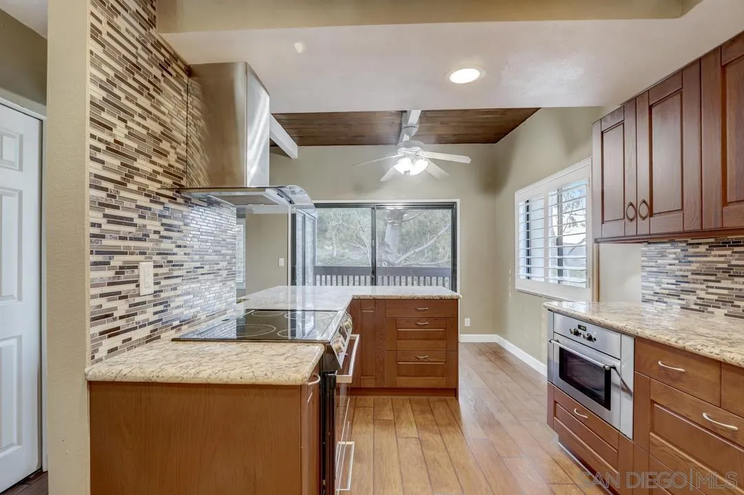 6395 Rancho Mission Road, Unit 15 San Diego, CA 92108 - Photo 14 of 21 a kitchen with granite countertop cabinets and wooden floor