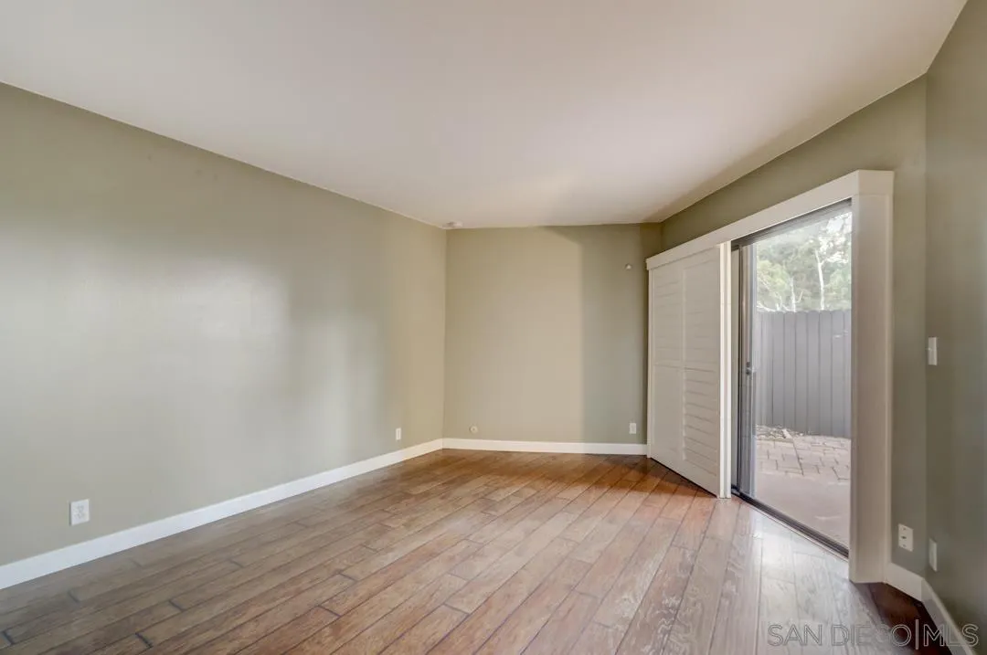 6395 Rancho Mission Road, Unit 15 San Diego, CA 92108 - Photo 15 of 21 a view of an empty room with wooden floor and a window