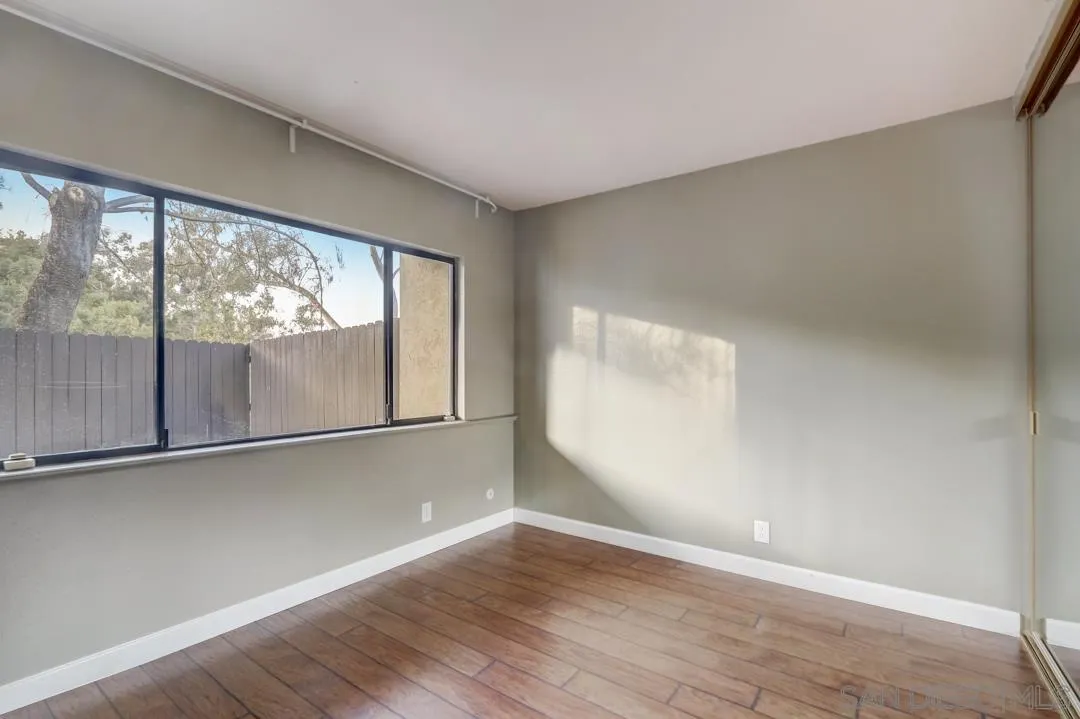 6395 Rancho Mission Road, Unit 15 San Diego, CA 92108 - Photo 18 of 21 an empty room with wooden floor and windows