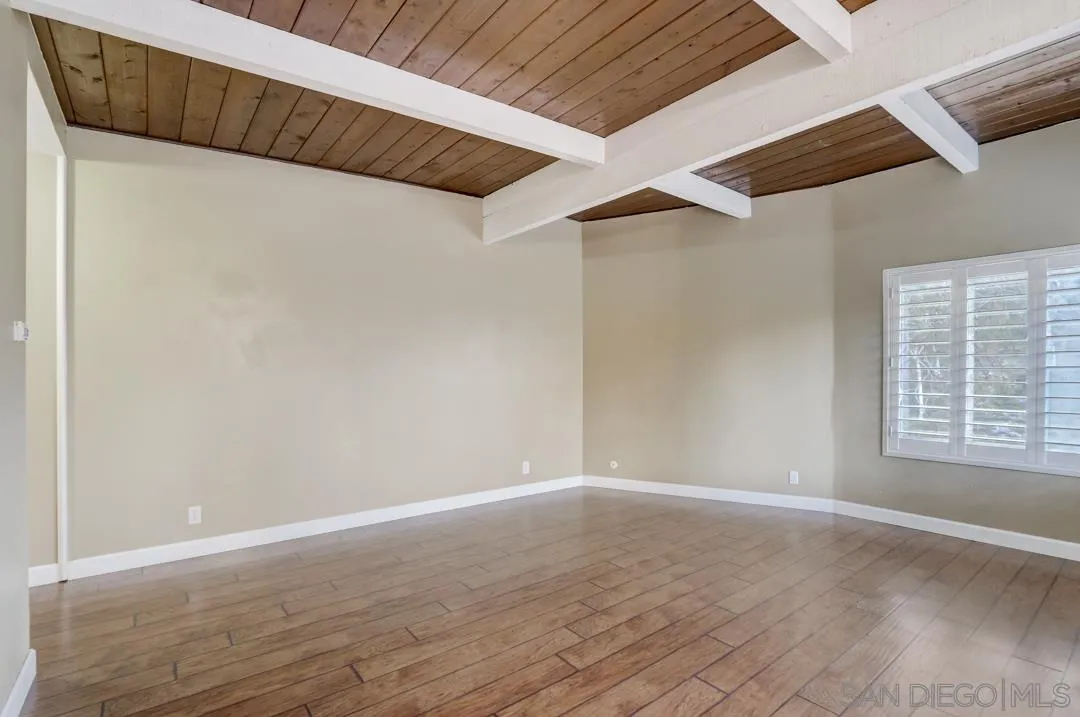 6395 Rancho Mission Road, Unit 15 San Diego, CA 92108 - Photo 5 of 21 a view of an empty room with wooden floor and a window