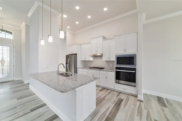 a kitchen with stainless steel appliances granite countertop a sink stove and refrigerator