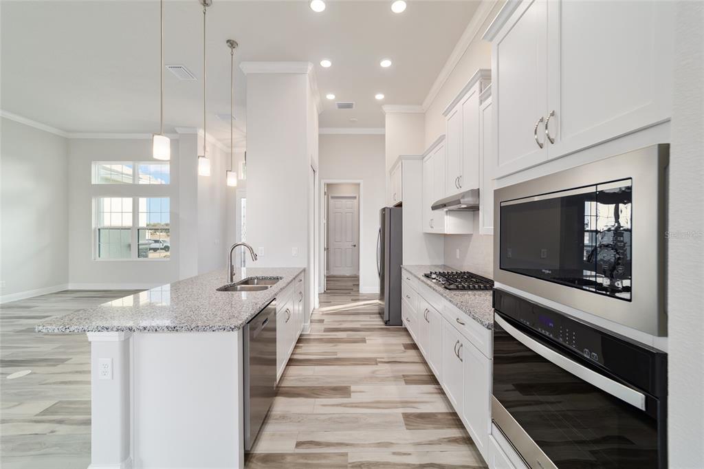1499 East Pegasus Lane Inverness, FL 34453 - Photo 14 of 46 a large kitchen with granite countertop a large stove top oven and sink