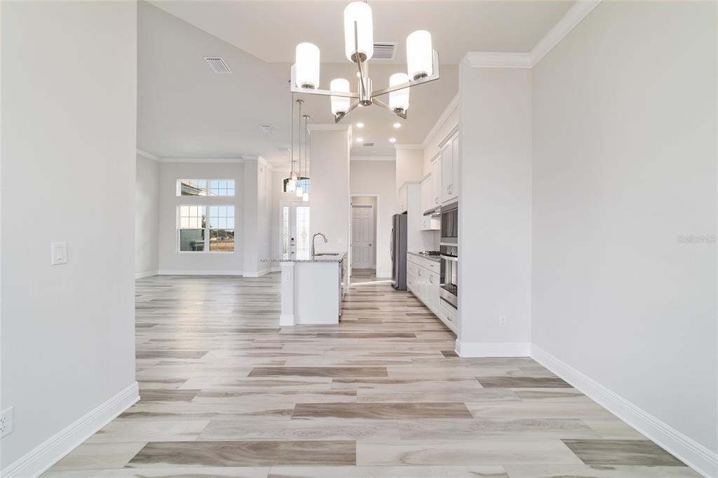 1499 East Pegasus Lane Inverness, FL 34453 - Photo 17 of 46 a view of a hallway with wooden floor and chandelier