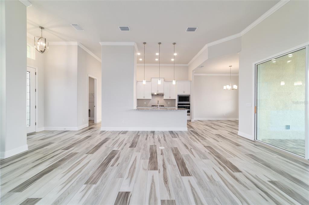 1499 East Pegasus Lane Inverness, FL 34453 - Photo 21 of 46 a view of a big room with wooden floor and a kitchen
