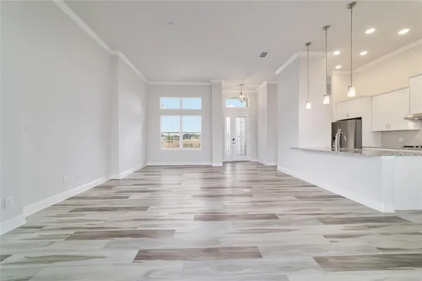 a view of empty room with kitchen and window