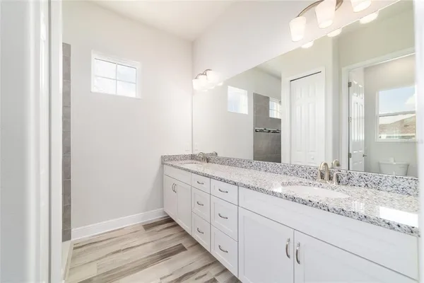 a bathroom with a granite countertop sink and a mirror