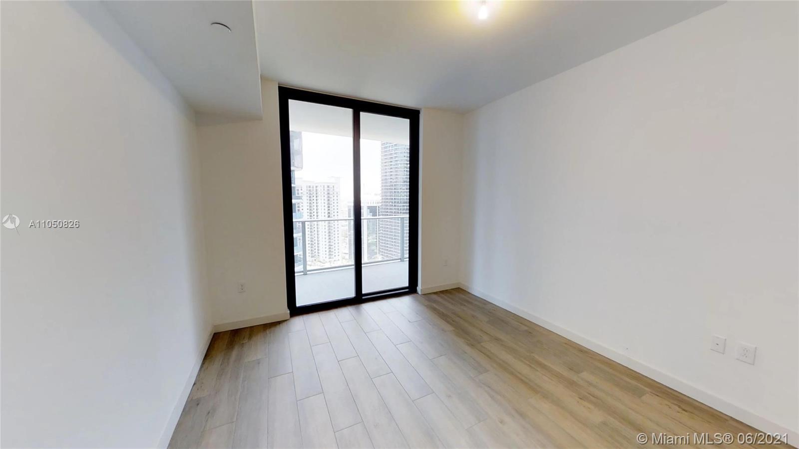 1010 Brickell Avenue, Unit 3209 Miami, FL 33131 - Photo 4 of 31 a view of an empty room with wooden floor and a window