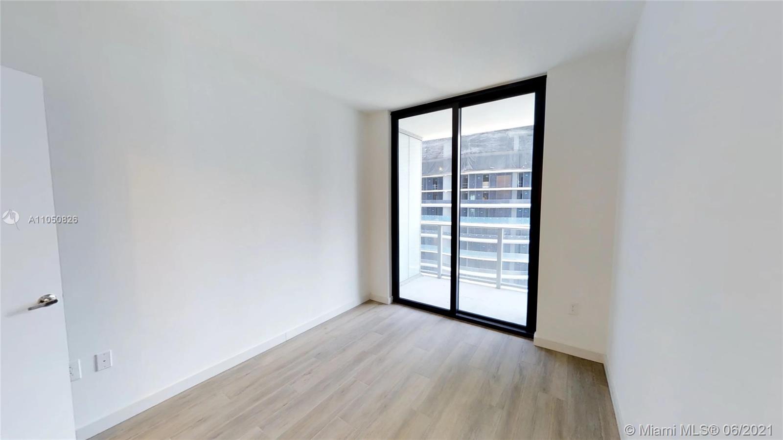1010 Brickell Avenue, Unit 3209 Miami, FL 33131 - Photo 10 of 31 an empty room with wooden floor and windows