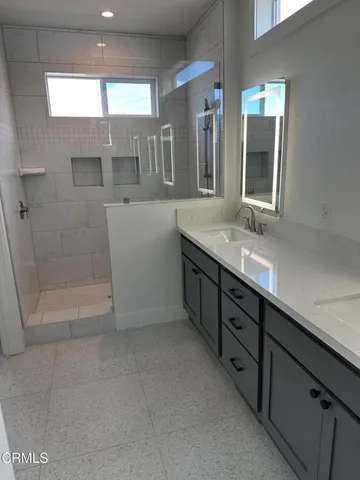 a bathroom with a glass door shower and sink