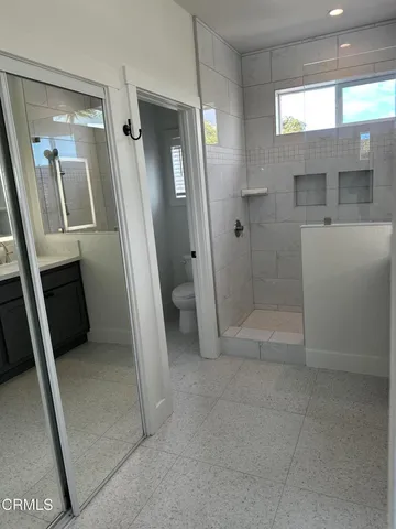 a bathroom with a granite countertop sink a toilet and shower