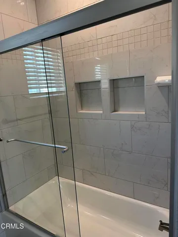 a bathroom with a granite countertop toilet a sink a mirror and a window