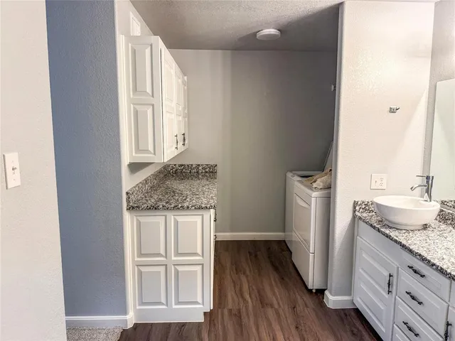a bathroom with a granite countertop sink and a mirror
