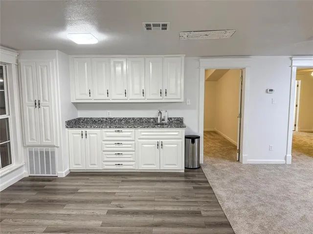 a kitchen with granite countertop white cabinets and stainless steel appliances