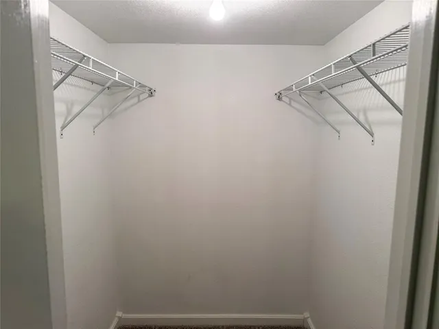 a view of walk in closet with racks on the wall