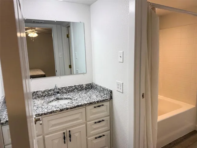 a bathroom with a granite countertop sink and a mirror