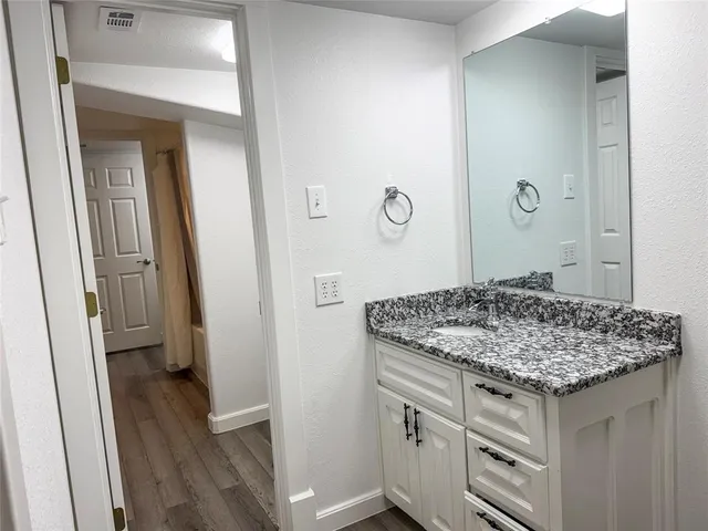 a bathroom with a granite countertop sink and a mirror