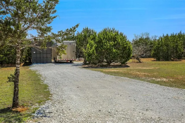 a view of a field with trees in the background