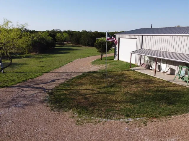 a backyard of a house with a yard and outdoor seating
