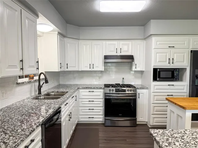 a kitchen with stainless steel appliances granite countertop a stove and a sink