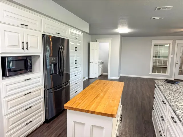 a kitchen with stainless steel appliances granite countertop a refrigerator and a stove top oven