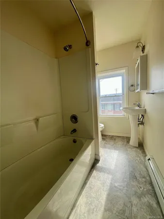 a bathroom with a tub a sink and a shower
