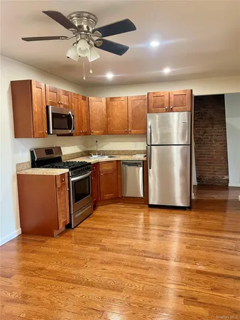 a kitchen with stainless steel appliances granite countertop a stove top oven a refrigerator a sink with a dining table and chairs