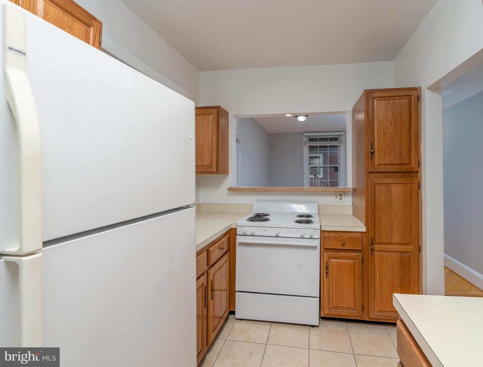 14 East Mt Vernon Place, Unit 15 Baltimore, MD 21202 - Photo 14 of 29 a kitchen with a refrigerator sink stove and cabinets