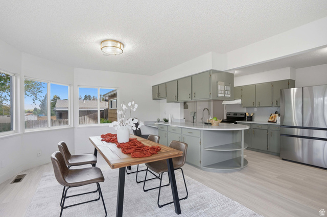 6889 South Village Road Salt Lake City, UT 84121 - Photo 11 of 44 Bright dining area with large bay windows, light LVP Tile flooring, and a modern ceiling fixture