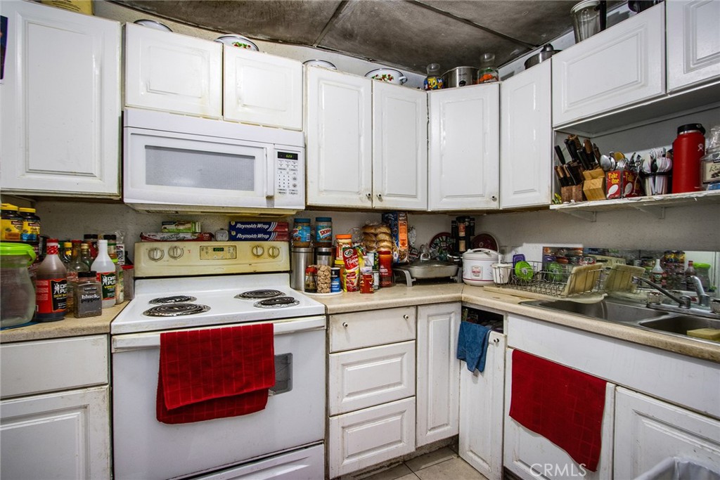 5929 Adobe Road Twentynine Palms, CA 92277 - Photo 21 of 33 a kitchen with stainless steel appliances granite countertop a sink a stove and cabinets