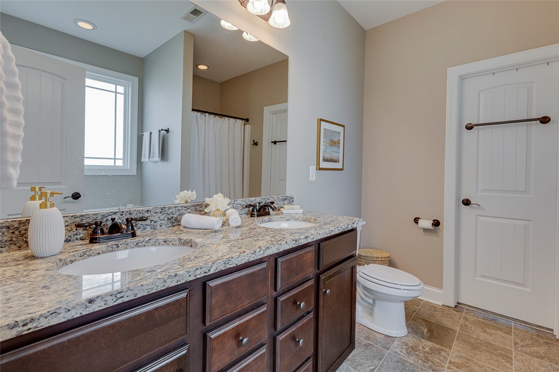 203 Streams Way Anderson, SC 29625 - Photo 10 of 47 This spacious bathroom features a double vanity with ample storage and a contemporary toilet.