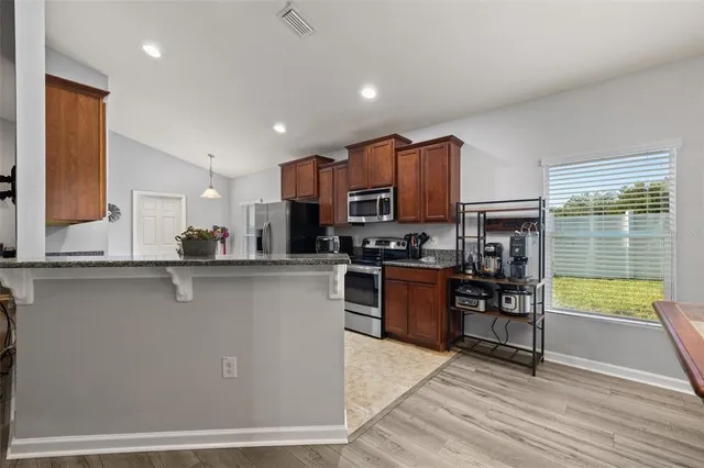 a view of a kitchen with a refrigerator and a sink