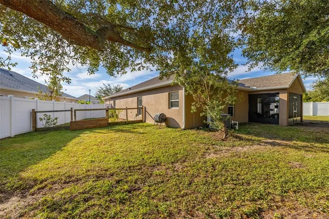a front view of a house with a garden and tree